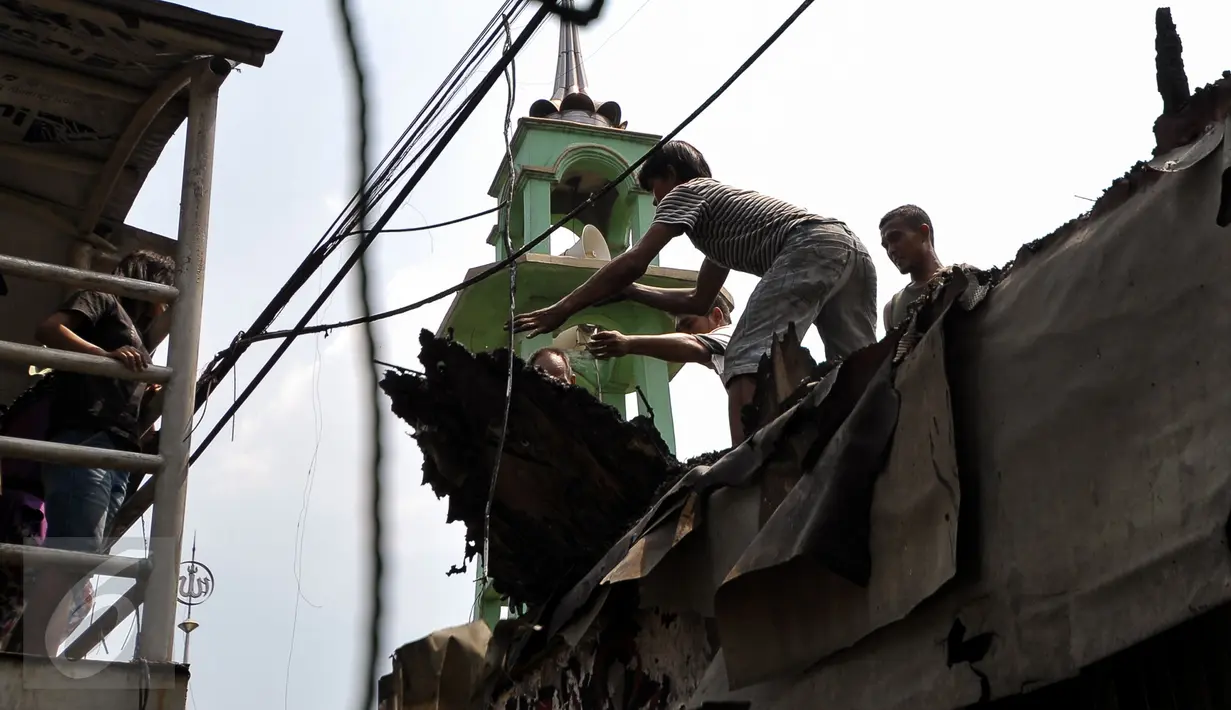 Warga bergotong royong membersihkan sisa kebakaran yang melanda kawasan Pasar Gembrong, Jakarta, Rabu (5/8/2015). Kebakaran yang terjadi pada Selasa (4/8) lalu membakar sekitar 25 rumah dan toko mainan. (Liputan6.com/Yoppy Renato)
