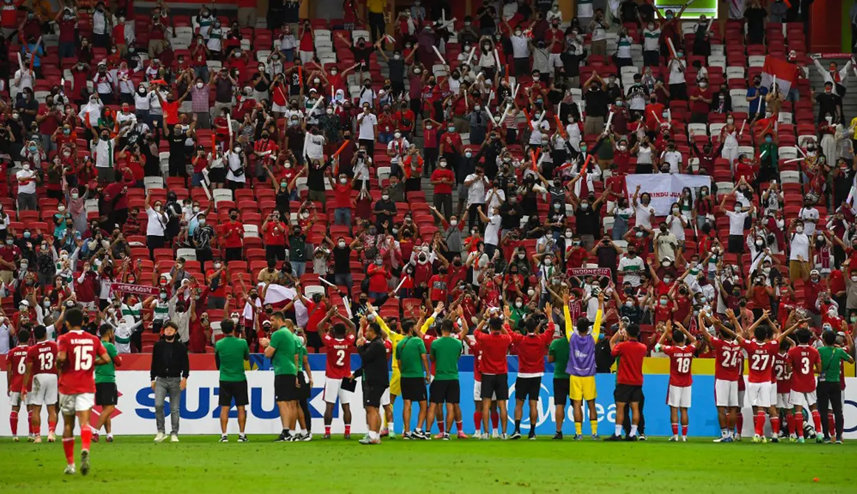 Para pemain Indonesia menyapa para penggemarnya usai melawan Thailand pada pertandingan sepak bola leg kedua final Piala AFF 2020 di National Stadium, Singapura, Sabtu (1/1/2022). Pertandingan berakhir dengan skor 2-2. (Roslan RAHMAN/AFP)