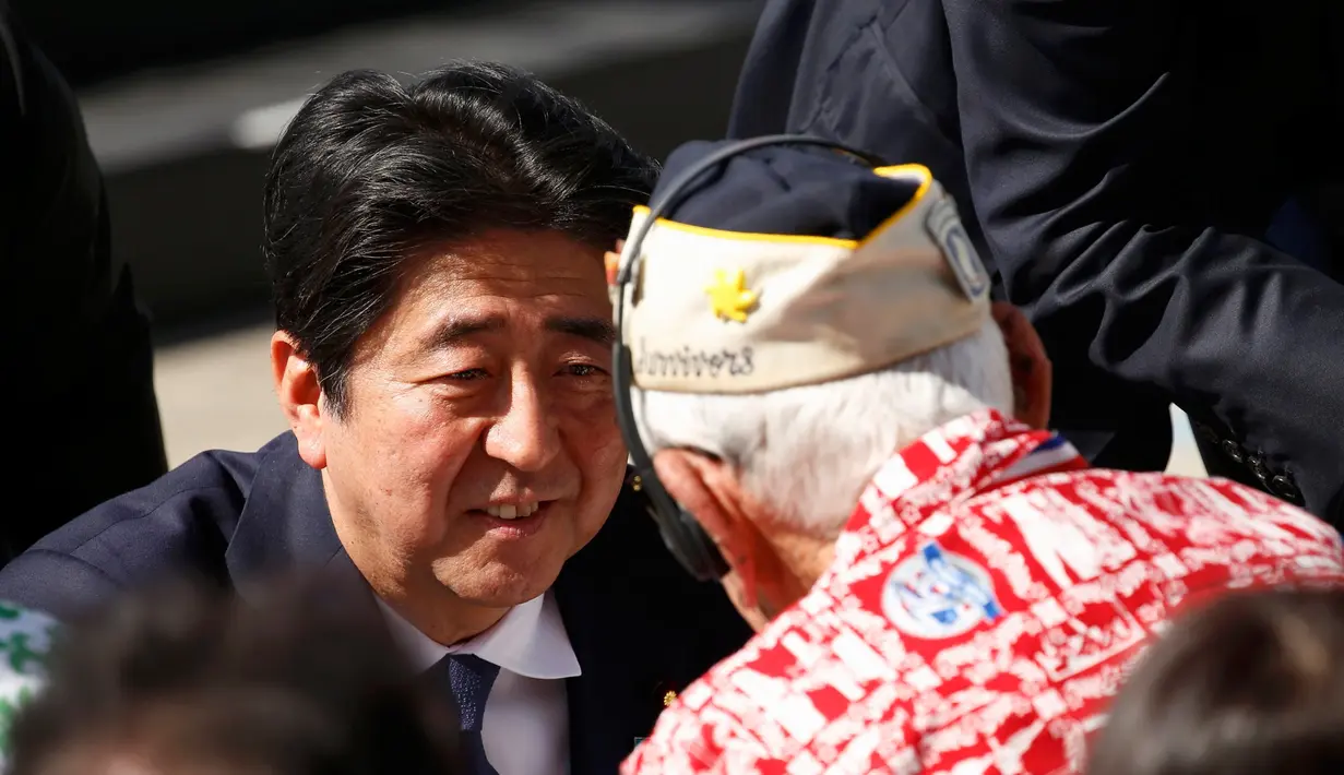 PM Jepang Shinzo Abe menyapa korban selamat Pearl Harbor setelah menyampaikan pidato dengan Presiden AS Barack Obama di Joint Base Pearl Harbor-Hickam, Hawaii, (27/12). (REUTERS/Kevin Lamarque)