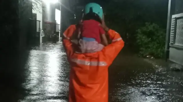 Seorang petugas mengevakuasi seorang anak dari banjir lahar dingin Gunung Semeru. (Istimewa)