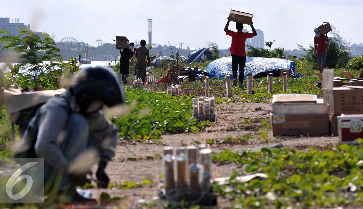Sejumlah pekerja membawa kardus berisi kembang api yang dipersiapkan untuk perayaan malam tahun baru 2016 di pantai Ancol, Jakarta, Rabu (30/12). Sebanyak 20ribu lebih kembang api akan di tembakan pada malam tahun baru. (Liputan6.com/Yoppy Renato)