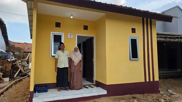 Purwanto bersama istrinya foto di depan rumahnya di Desa Ngembalrejo, Kecamatan Bae Kudus, usai direnovasi dalam program RSLH. (Liputan6.com/ist)