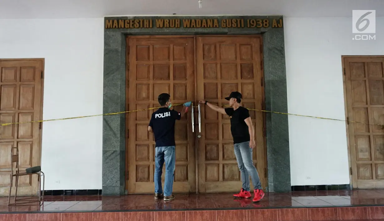 Petugas memasang garis polisi usai penyerangan di Gereja St Lidwina Bedog, Sleman, Yogyakarta, Minggu (11/2). Terduga pelaku telah berhasil dilumpuhkan polisi. (Liputan6.com/Arya Manggala)