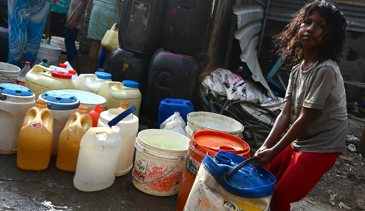Seorang gadis menyeret ember berisi air yang dikumpulkan dari truk tangki air perusahaan kota di lingkungan berpenghasilan rendah di New Delhi pada Kamis (3/6/2021). Pada tahun 2018, lebih dari 600 juta orang di India tidak memiliki akses air bersih yang cukup. (Money SHARMA / AFP)