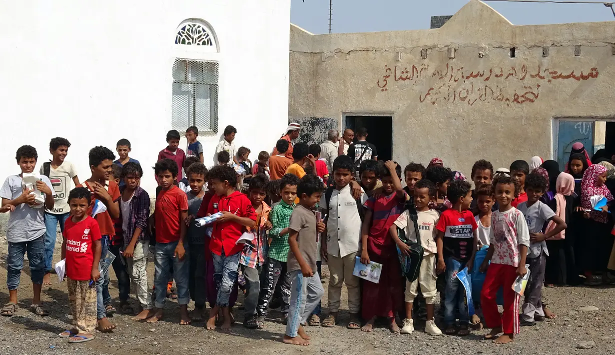 Anak-anak Yaman berkumpul di halaman gedung sekolah yang rusak sebelum menghadiri kelas, di provinsi barat Hodeidah yang dilanda perang (5/9/2021).  Konflik antara pemerintah dan pemberontak Houthi menjadi penyebabnya. (AFP/Khaled Ziad)