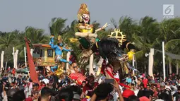 Peserta mengarak ogoh-ogoh dalam Festival Ogoh-Ogoh di Pantai Lagoon Ancol, Jakarta, Minggu (18/3). Festival ini digelar untuk memperkenalkan keberagaman budaya Hindu Dharma Bali. (Liputan6.com/Arya Manggala)