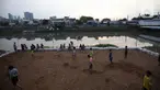 Sejumlah anak bermain sepak bola di sebuah lahan kosong di Pinggir Banjir Kanal Barat, Jakarta, Selasa (12/10/2021). Alih fungsi lahan menjadi kawasan hunian dan perkantoran mengakibatkan semakin minimnya lahan bermain bola bagi anak di Ibu kota.  (Liputan6.com/Johan Tallo)