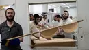 Orang-orang Yahudi ultraortodoks membuat roti matzo di sebuah toko roti di Ashdod, Israel, Selasa (4/4/2023). Matzo adalah roti tanpa ragi yang secara tradisi menjadi simbol keprihatinan bangsa Yahudi. (AP Photo/Tsafrir Abayov)