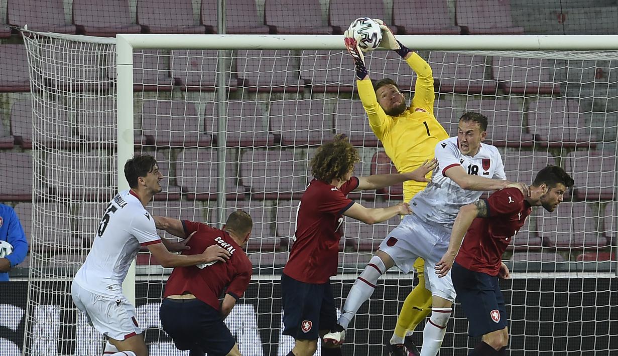 Kiper Republik Ceska, Tomas Vaclik (atas) berhasil menangkap bola dari ancaman pemain Albania dalam laga uji coba menjelang Euro 2020 di Praha, Republik Ceska, Selasa (8/6/2021). Republik Ceska menang 3-1 atas Albania. (AFP/Michal Cizek)