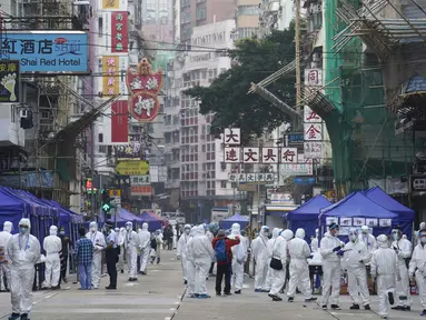 Penyelidik pemerintah yang mengenakan pakaian pelindung berkumpul di daerah Yau Ma Tei di Hong Kong, Sabtu (23/1/2021). Ribuan warga Hong Kong diperintahkan tetap tinggal di rumah setelah otoritas setempat memberlakukan penguncian ( lockdown ) untuk pertama kalinya sejak pandemi COVID-19 merebak. (A