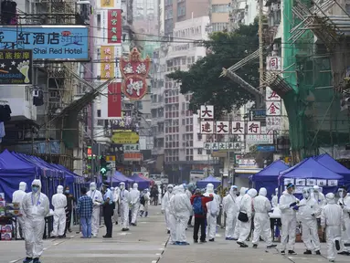 Penyelidik pemerintah yang mengenakan pakaian pelindung berkumpul di daerah Yau Ma Tei di Hong Kong, Sabtu (23/1/2021). Ribuan warga Hong Kong diperintahkan tetap tinggal di rumah setelah otoritas setempat memberlakukan penguncian ( lockdown ) untuk pertama kalinya sejak pandemi COVID-19 merebak. (A