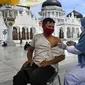Seorang pria menerima dosis vaksin virus corona COVID-19 Moderna saat pelaksanaan vaksinasi di Masjid Raya Baiturrahman, Banda Aceh, Aceh, Selasa (7/9/2021). (CHAIDEER MAHYUDDIN/AFP)
