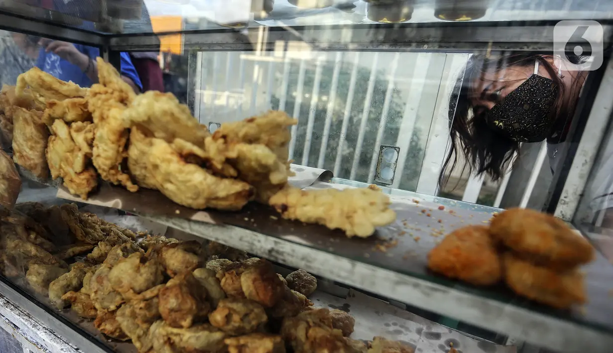 Pembeli melihat-lihat menu berbuka puasa atau takjil jelang waktu berbuka puasa di kawasan Radio Dalam, Jakarta Selatan, Senin (4/4/2022). Pedagang musiman yang menjual aneka takjil memanfaatkan momen bulan suci Ramadhan 1443 H. (Liputan6.com/Johan Tallo)