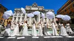 Pengantin perempuan yang mengenakan gaun pernikahan mereka melakukan flashmob saat aksi protes di Trevi Fountain, Roma, Selasa (7/7/2020). Mereka memprotes kebijakan pemerintah Italia yang masih melarang adanya acara pernikahan, meski penerapan lockdown sudah dilonggarkan. (Tiziana FABI/AFP)