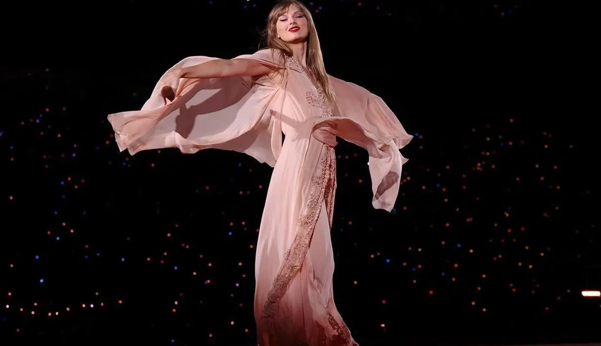 Taylor Swift menampilkan tariannya di atas panggung. Potret menawan ini memperlihatkan pose Taylor Swift dengan gaun yang flowy dan lipstik merahnya yang ikonis. [Foto: Instagram/taylorswift]