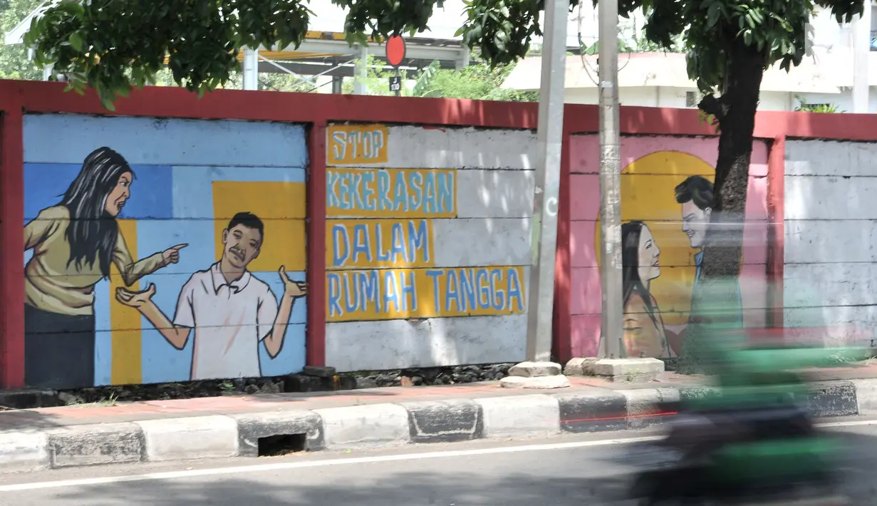 Pengendara melintasi mural bertema 'Tolak Kekerasan Perempuan dan Pelecehan Seksual' di kawasan Jatinegara, Jakarta, Senin (17/12). Mural tersebut juga mengajak masyarakat untuk melindungi kaum perempuan. (Merdeka.com/Iqbal S. Nugroho)