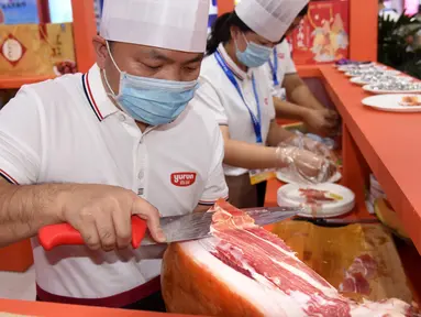 Para peserta pameran menyiapkan produk daging dalam Pameran Industri Daging Internasional China ke-18 di Qingdao, Provinsi Shandong, China, 10 September 2020. (Xinhua/Li Ziheng)