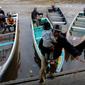 Pria menggendong anaknya turun dari perahu sampan di Sungai Kapuas, Pontianak, Kalimantan Barat, Sabtu (22/8/2015). Perahu Sampan saat ini masih diminati warga sebagai pilihan moda transportasi sederhana di Sungai Kapuas. (Liputan6.com/Faizal Fanani)