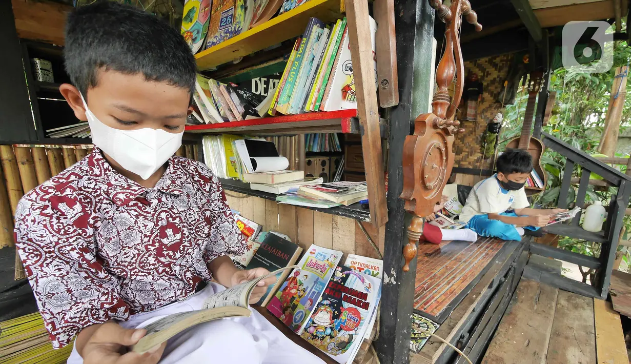 Anak-anak membaca buku di pustaka mini Bale Buku, Kramat Jati, Jakarta Timur, Kamis (20/01/2022). Bale buku yang diresmikan pada Sabtu (15/1) dibangun dari barang-barang bekas oleh komunitas Baca Bale Buku. (Liputan6.com/Herman Zakharia)