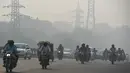 Kendaraan bermotor menembus kabut asap pekat yang menyelimuti jalan di New Delhi, Selasa (12/11/2019). Kabut asap kembali menyelimuti ibu kota India setelah akhir pekan dengan udara cerah dan cuaca yang lebih baik. (Photo by Money SHARMA / AFP)