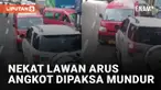 Aksi tidak mematuhi peraturan lalu lintas dilakukan oleh pengemudi angkot yang melawan arus jalan mengundang perhatian