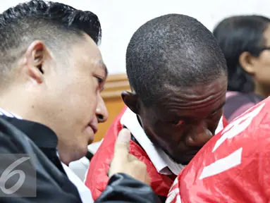 Terdakwa kasus narkotika sabu 6,3 kg Arinze Petrus Eneh berbincang dengan kuasa hukumnya saat mengikuti sidang vonis di PN Jakarta Barat, Rabu (11/5). Sidang dengan tuntutan hukuman mati ditunda hingga minggu depan. (Liputan6.com/Immanuel Antonius)