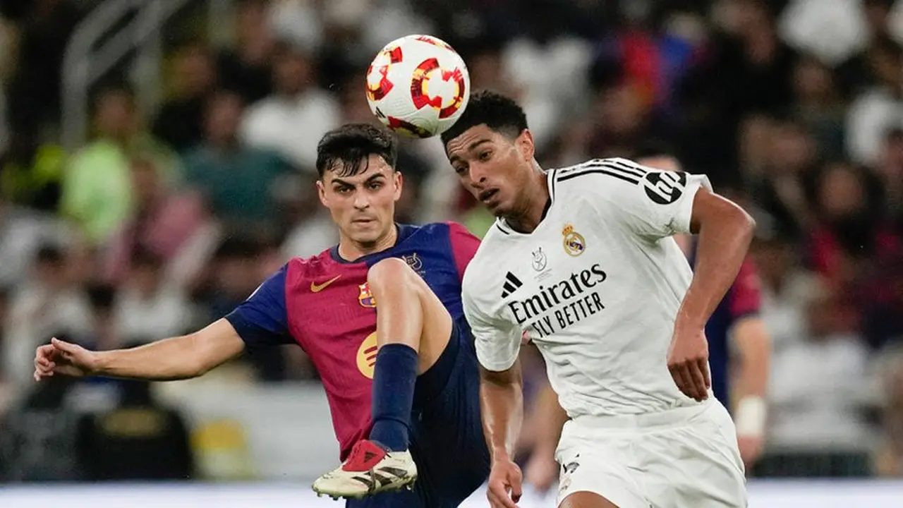 Duel Pedri dan Jude Bellingham dalam laga final Supercopa de Espana antara Real Madrid vs Barcelona, Senin (13/1/2025). (c) AP Photo/Altaf Qadri