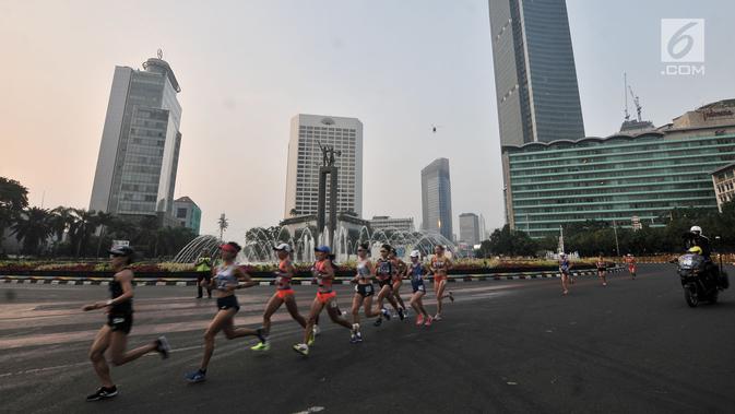 Pelari putri melintasi Jalan MH Thamrin saat mengikuti lari maraton putri nomor 42 km Asian Games 2018, Jakarta, (26/8). Medali Perunggu diraih Kim Hye Song dari Korea Utara dengan catatan waktu 2 jam 37 menit 20 detik. (Merdeka.com/Iqbal S. Nugroho)