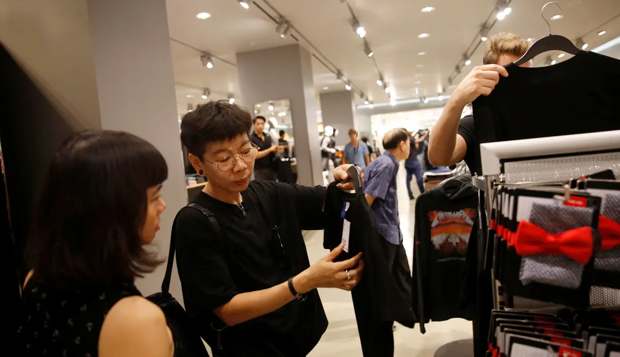 Orang-orang berbelanja pakaian hitam atau putih untuk menghadiri penghormatan terakhir atas meninggalnya Raja Thailand Bhumibol Adulyadej di sebuah mall Bangkok, Thailand (15/10). (REUTERS / Edgar Su)