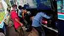 Para penumpang memasukkan barangnya ke dalam bagasi bus. Jakarta, Kamis (24/7/14) (Liputan6.com/Faizal Fanani)