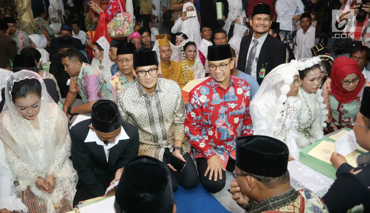 Gubernur DKI Jakarta, Anies Baswedan dan Wagub Sandiaga Uno saat meninjau nikah massal di malam pergantian tahun di Jalan MH Thamrin, Jakarta, Minggu (31/12).  Sebanyak 430 pasangan melakukan nikah massal. (Liputan6.com/Angga Yuniar)