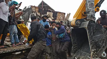 Tim penyelamat membantu korban yang ditarik keluar dari reruntuhan gedung pemerintah yang runtuh saat gempa bumi di Mamuju, Sulawesi Barat, Jumat (15/1/2021). Gempa bermagnitudo 6,2 mengguncang Mamuju, Sulawesi Barat. (AP Photo/Azhari Surahman)