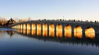 Foto yang diabadikan pada 4 Desember 2020 ini menunjukkan matahari terbenam yang menyinari Jembatan 17 Lengkung di Istana Musim Panas di Beijing, ibu kota China. (Xinhua/Chen Jianli)