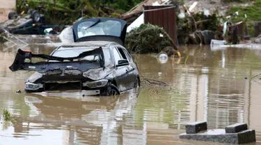 Puing-puing dan sebuah mobil yang rusak akibat banjir di desa Bavarian, Munich , Jerman , 2 Juni 2016. Petugas menemukan 3 wanita  yang tewas diruang bawah tanah rumah yang terendam banjir dan 1 tewas akibat tenggelam di sungai. (REUTERS / Michaela Rehle)