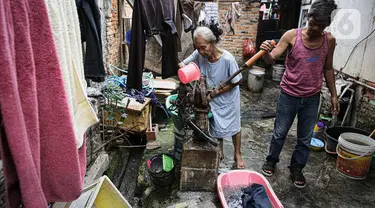 Warga mengambil air menggunakan pompa tangan di kawasan Jakarta, Rabu (6/10/2021). Warga Jakarta akan dilarang menggunakan air tanah yang menyebabkan penurunan muka tanah semakin tinggi menyusul upaya dalam mencegah penggunaan air tanah secara terus-menerus. (Liputan6.com/Faizal Fanani)