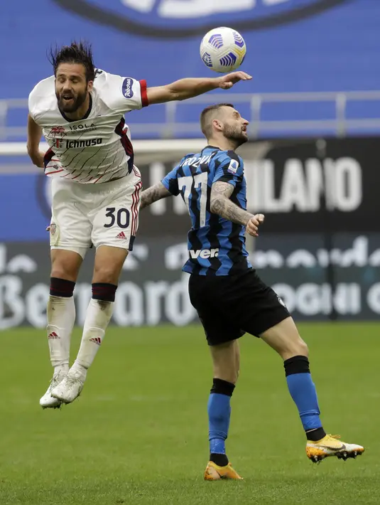 Gelandang Inter Milan, Marcelo Brozovic berebut bola dengan pemain Cagliari, Leonardo Pavoletti pada pertandingan lanjutan Liga Serie A Italia di stadion San Siro, Italia, Minggu (11/4/2021). Inter Milan kembali unggul 11 poin atas AC Milan yang berada di posisi kedua klasemen. (AP Photo/Luca Bruno)
