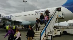 Para penumpang turun dari pesawat maskapai Condor saat tiba di Bandara Madeira. Kota ini merupakan tempat kelahiran Cristiano Ronaldo. (Bola.com/Reza Khomaini)