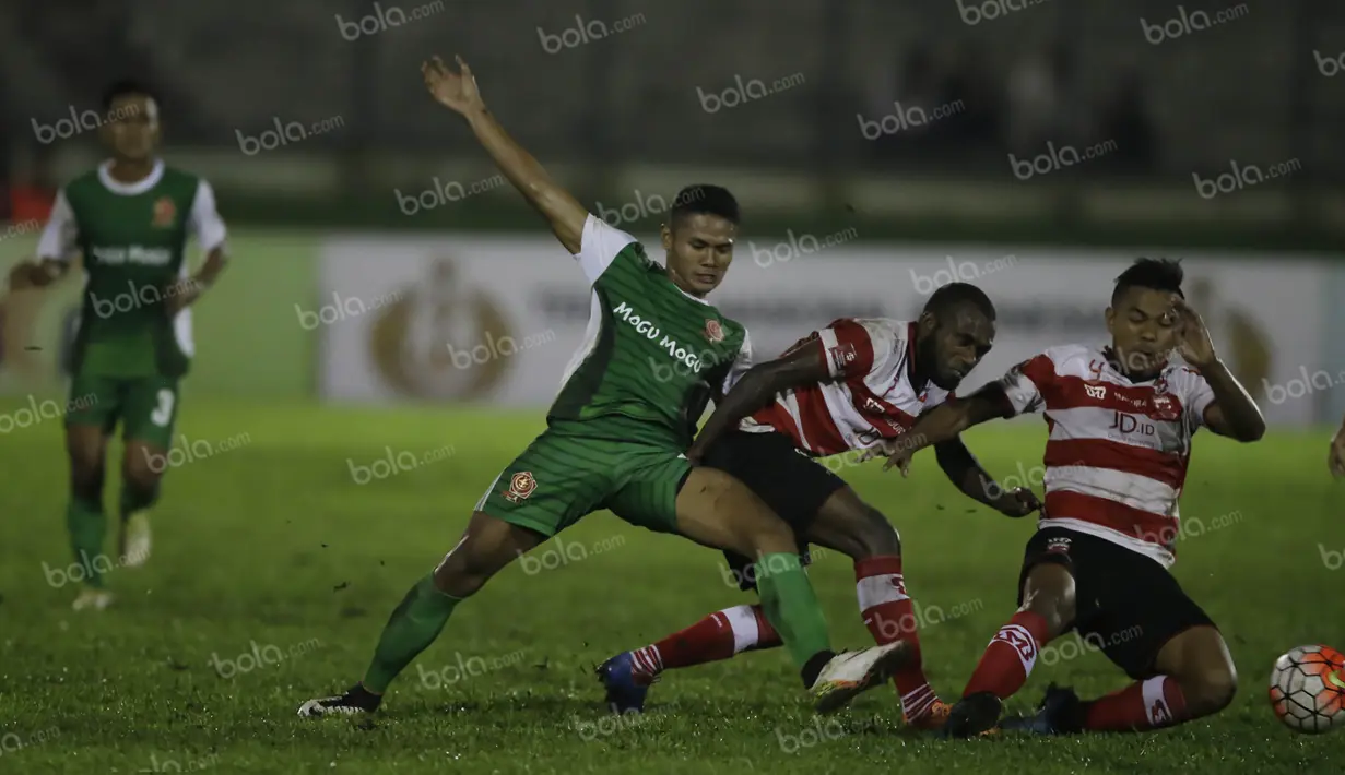 Pemain PS TNI, Dimas Drajad, berebut bola dengan pemain Madura United, Engelberd Sani dan Asep Berlian (kanan), dalam laga Torabika Soccer Championship presented by IM3 Ooredoo di Stadion Siliwangi, Bandung, Minggu (1/5/2016). (Bola.com/Vitalis Yogi Trisn