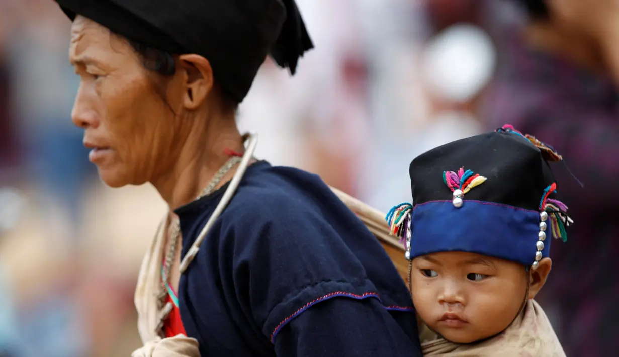 Seorang ibu menggendong buah hatinya saat berjalan-jalan di desa Pansang, wilayah pemberontak Wa, di Myanmar, 3 Oktober 2016. (REUTERS/Soe Zeya Tun)