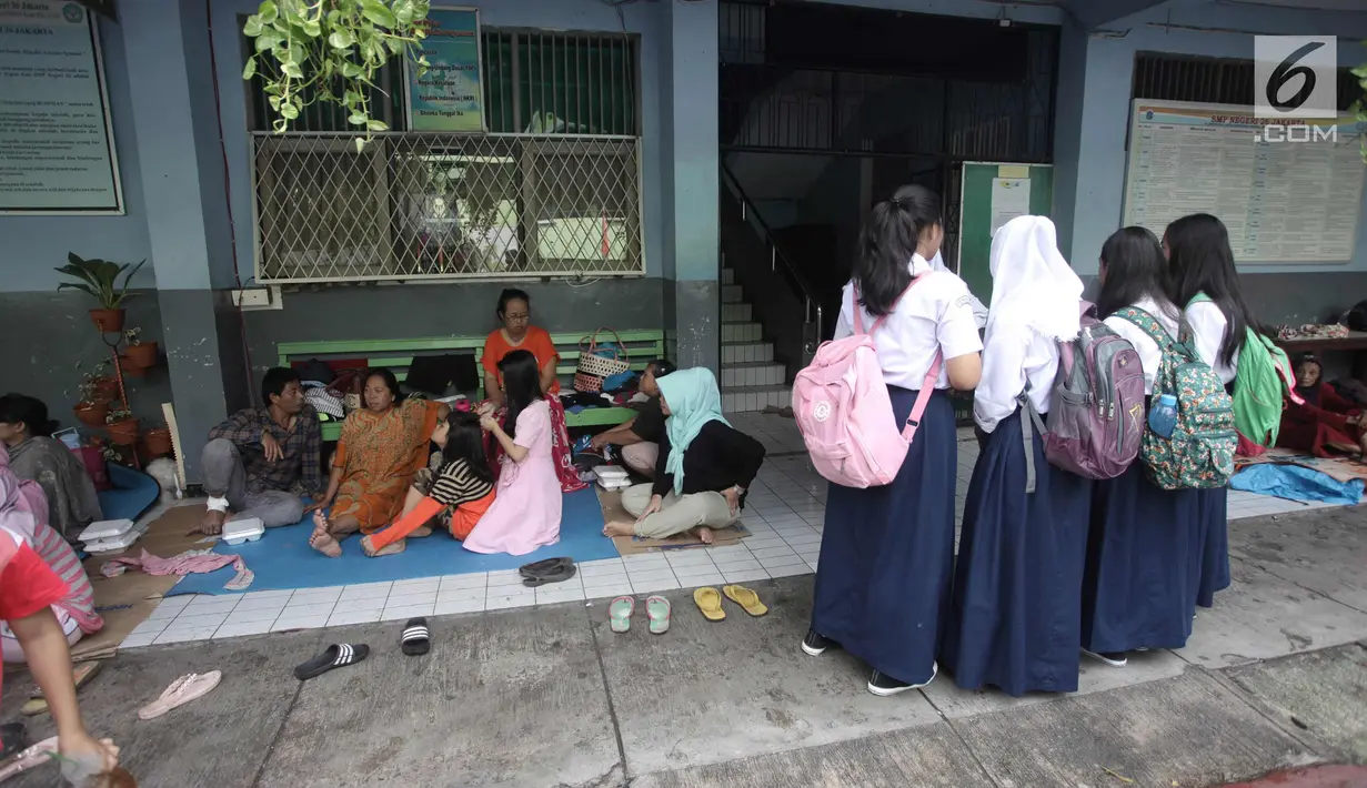 Sejumlah murid beraktivitas di Gedung SMP Negeri 26, Jalan Kebon Pala, Kampung Melayu, Jatinegara, Jakarta Timur, Selasa (6/2). Sebanyak 42 KK mengungsi di tempat tersebut. (Liputan6.com/Arya Manggala)