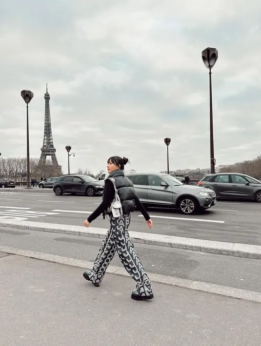 Jessica Mila menghadirkan tampilan city girl saat berlibur ke Paris. Dengan turtleneck rajut berwarna hitam yang ditumpuknya dengan puffer vest hitam, ia memadukan penampilannya ini dengan celana panjang bermotif logo brand. [Foto: Instagram/jsmila]