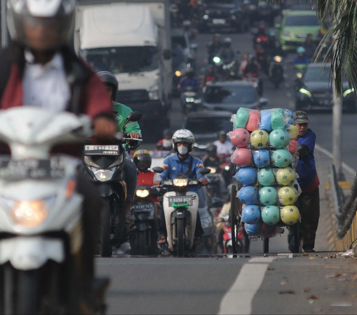 Seorang pedagang keliling mendorong gerobaknya dengan berjalan kaki saat melewati flyover di Buaran, Jakarta, Kamis (2/5/2024). Flyover Buaran sangat berbahaya bagi pejalan kaki. Pasalnya, jalan layang ini tak dilengkapi ruang bagi pejalan kaki, baik itu 