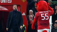 Manajer&nbsp;sementara Manchester United asal Belanda, Ruud van Nistelrooy (L), disambut oleh maskot klub, Fred The Red, menjelang kick-off pada pertandingan babak 16 besar Piala Liga Inggris (Carabao Cup) antara Manchester United dan Leicester City di Old Trafford di Manchester, barat laut Inggris, Kamis dini hari WIB (31/10/2024). (Darren Staples/AFP)