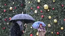 Orang-orang berjalan saat salju turun di Madrid, Spanyol, Jumat (8/1/2021). Badai Filomena mengakibatkan salju lebat turun di Madrid dan seluruh Spanyol. (GABRIEL BOUYS/AFP)