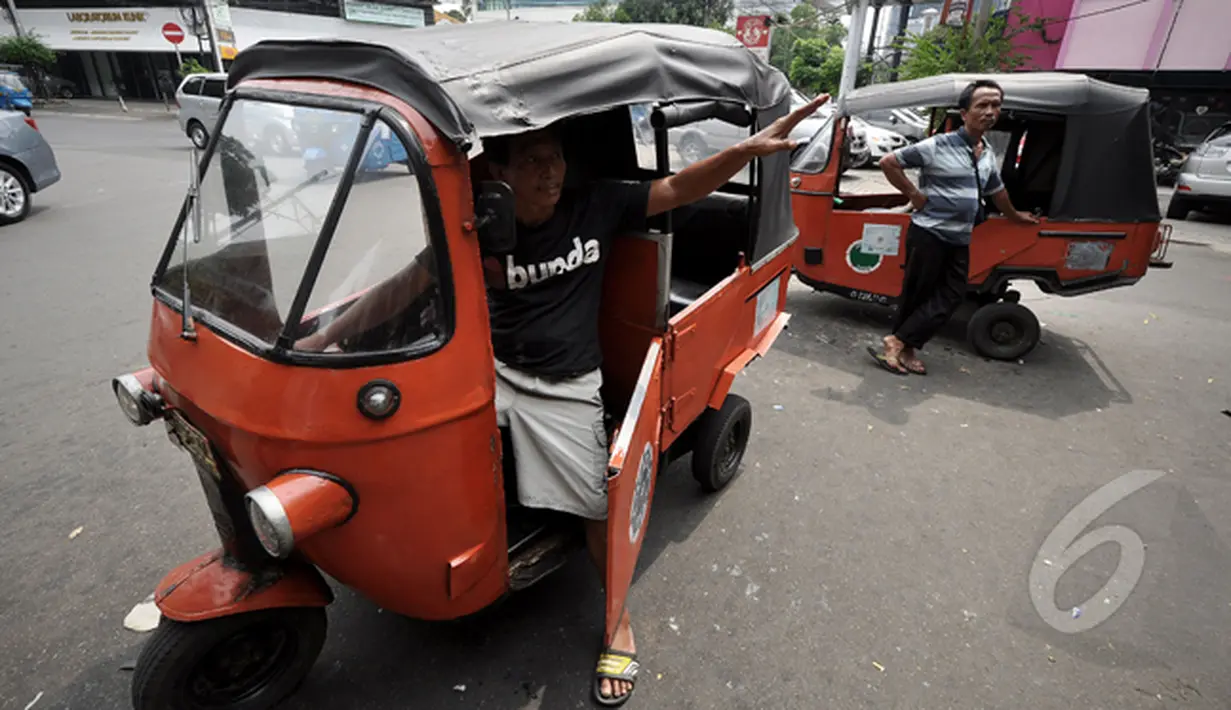 Pengemudi bajaj menawarkan jasa kepada calon penumpang di kawasan Stasiun Gondangdia, Jakarta, Selasa (25/2/2015). Para pemilik bajaj orange yang bermesin 2 tak mengaku siap untuk menjadi bajaj biru berbahan bakar gas (Liputan6.com/Faizal Fanani)