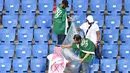 Suporter Arab Saudi memunguti sampah di tribun seusai laga melawan Uruguay pada pertandingan kedua Grup A Piala Dunia 2018 di Rostov Arena, Rostov-on-Don, Rabu (20/6). Kalah 0-1, Arab Saudi menjadi tim kedua yang tersingkir setelah Maroko (AFP/JOE KLAMAR)