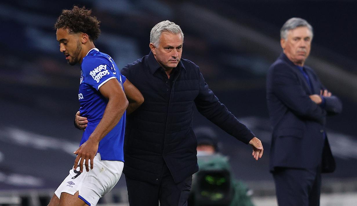 Pelatih Tottenham Hotspur, Jose Mourinho, dan pelatih Everton, Carlo Ancelotti, pada laga Premier League, Senin (6/7/2020). Mourinho rela langgar aturan jarak sosial demi memeluk Carlo Ancelotti. (AFP/Richard Heathcote)