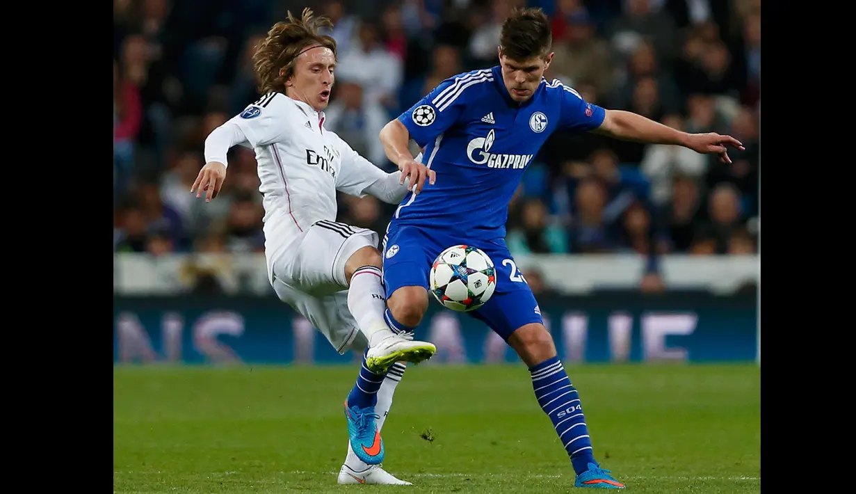 Gelandang Real Madrid, Luca Modric berebut bola dengan penyerang Schalke 04 Klaas-Jan Huntelaar di leg kedua 16 besar Liga Champions di Stadion Santiago Bernabeu, Madrid, Spanyol, (10/3/2015). Schalke 04 Menang 4-3 atas Real Madrid. (Reuters/Juan Medina)