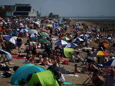 Orang-orang bersantai di kawasan Southend-on-Sea, bagian tenggara Inggris pada 12 Agustus 2024. (HENRY NICHOLLS/AFP)