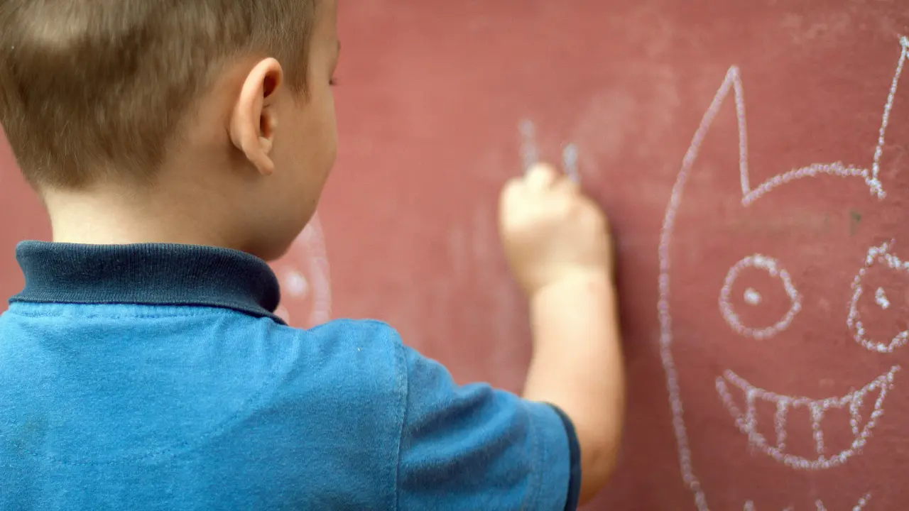 Anak sedang menggambar di dinding
